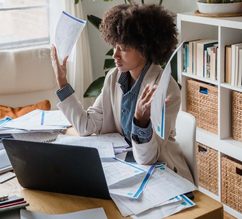 Staff overwhelmed by paperwork and invoices at a desk